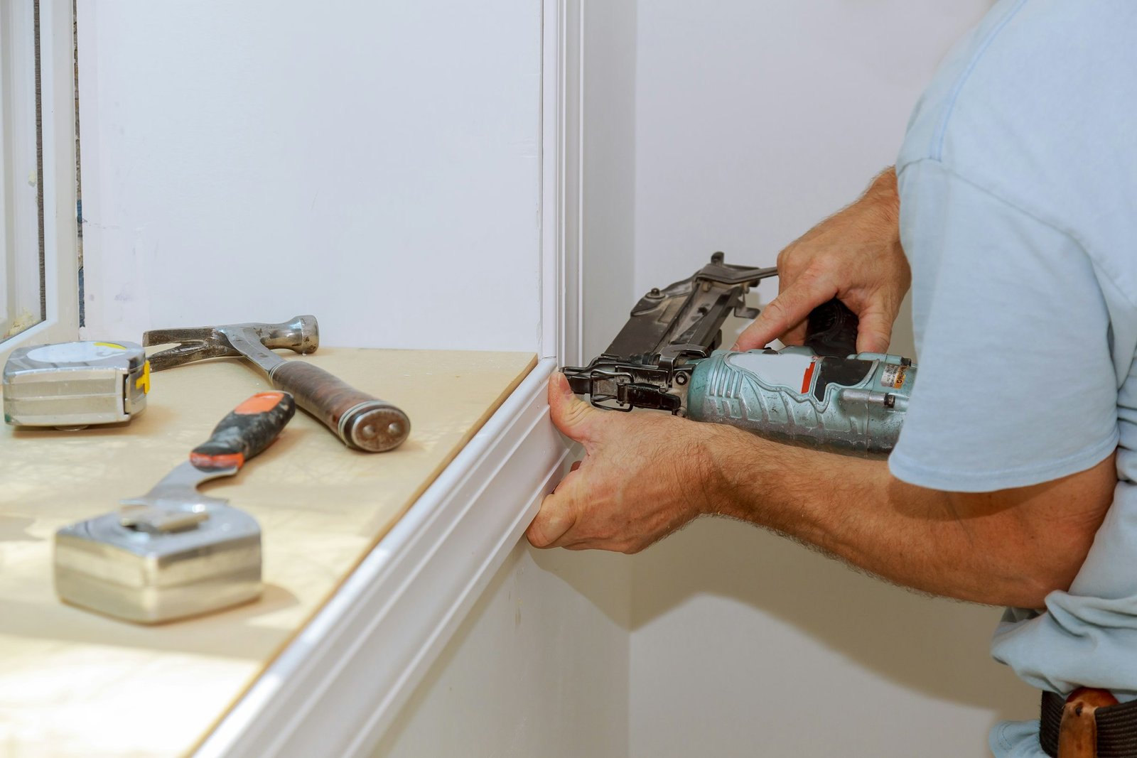 Worker installing trim around a window molding installed moldings materials