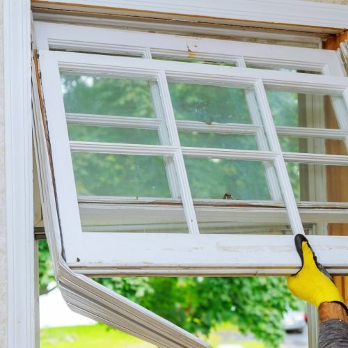 Worker hand removing old window replacing the old wooden window,